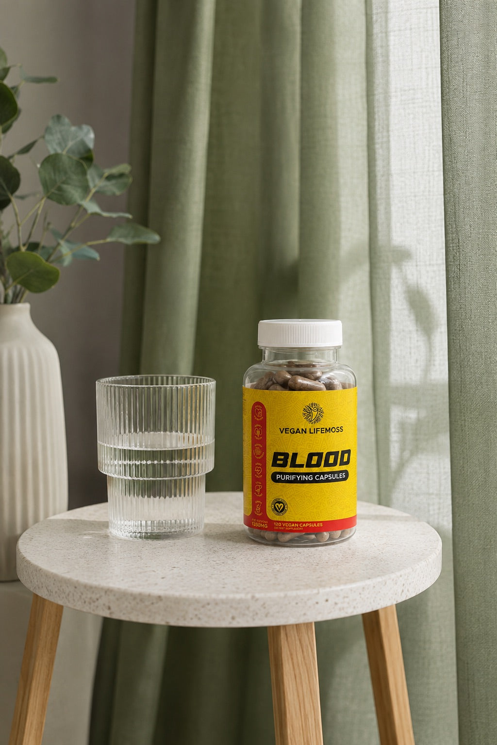 A bottle of Blood Purifying Capsules beside a glass of water on a side table